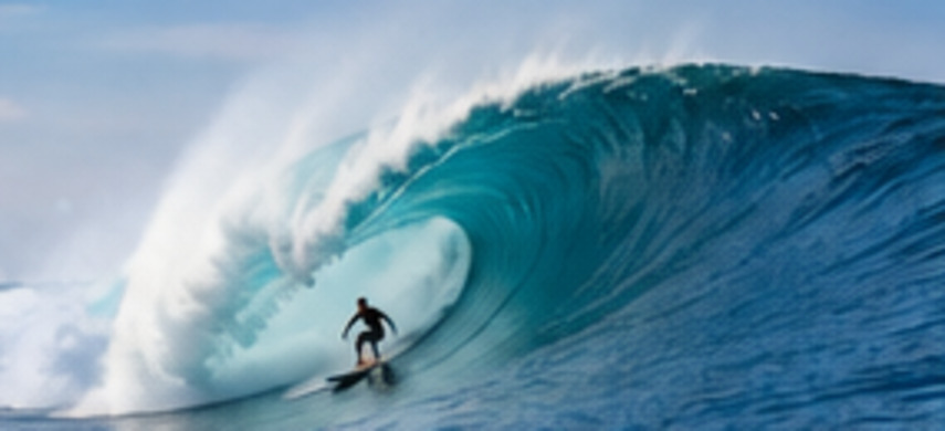 Surfer riding a wave at sunset